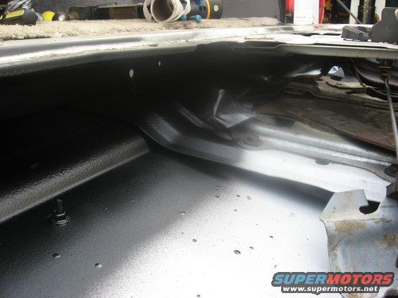 Interior view of a vehicle's cargo area with black textured coating