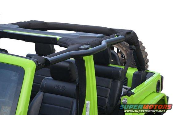 Green Jeep Wrangler interior with black leather seats and soft top frame. Spare tire visible