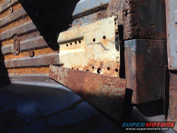 heavily rusted metal panels with many holes, some painted white