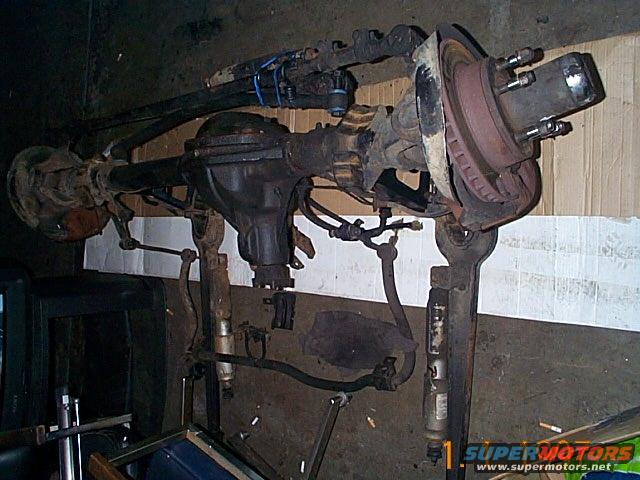 Dana 44 front axle assembly with disc brakes and steering linkage, mounted on a stand