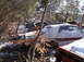 1974 Dodge Challenger - A collection of abandoned vehicles rests in a snowy, wooded junkyard.