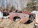 1974 Dodge Challenger - This 1974 Dodge Challenger is in rough shape, sitting in a junkyard with other vehicles.