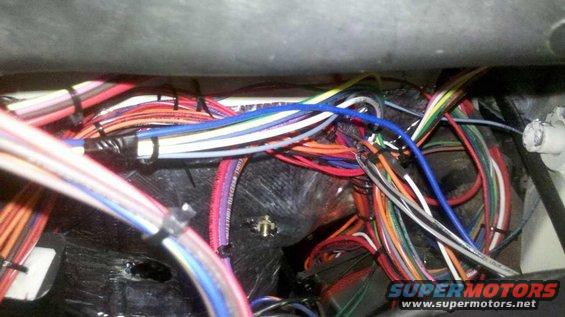 Tangled bundle of colorful wires in a vehicle's wiring harness