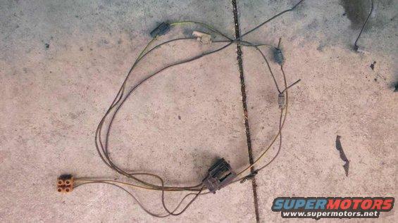 Wiring harness with multiple connectors and brown wires laid out on a concrete surface