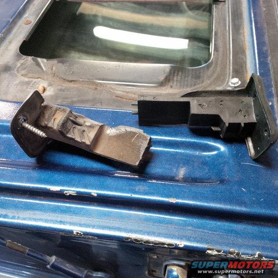 Broken latch mechanism on blue vehicle's tailgate, with visible screw and plastic parts