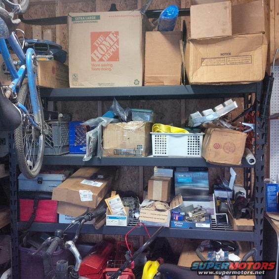 Shelves packed with boxes, a blue bicycle, and various items in a storage area