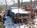 1974 Dodge Challenger - An old car sits abandoned in the snow, partially obscured by trees and brush.