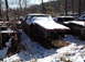 1974 Dodge Challenger - Multiple old cars sit abandoned in a snowy junkyard.