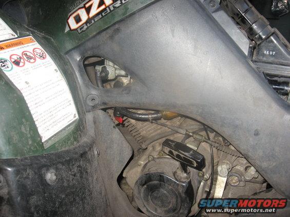 Green Suzuki QuadRunner engine with visible fuel line and carburetor
