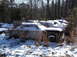 1974 Dodge Challenger - Multiple old vehicles sit abandoned and covered in snow amongst trees.
