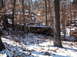 1974 Dodge Challenger - An old car sits abandoned in a snowy forest, partially obscured by trees and fallen leaves.