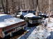 1974 Dodge Challenger - Abandoned vehicles sit under a blanket of snow in a wooded area, suggesting a long period of disuse.