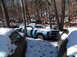 1974 Dodge Challenger - A weathered car sits in a snowy junkyard, surrounded by trees and other vehicles.