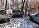 1974 Dodge Challenger - A collection of vehicles sits abandoned in a snowy, wooded area, with one truck clearly marked as 'Dodge'.