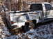 1974 Dodge Challenger - A white pickup truck sits abandoned in a snowy, wooded area, partially covered in leaves.