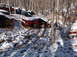 1974 Dodge Challenger - A junkyard scene with multiple vehicles covered in snow amongst trees.