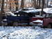 1974 Dodge Challenger - Multiple vehicles are seen in a snowy junkyard environment.