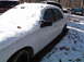 1974 Dodge Challenger - A white sedan sits covered in snow in a yard with other vehicles around.