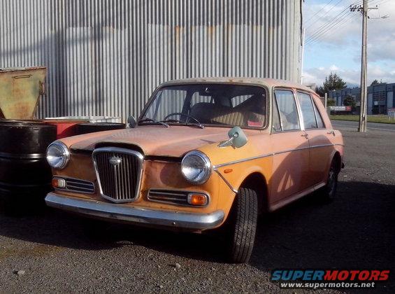 Orange sedan with chrome bumper and grille, parked outdoors
