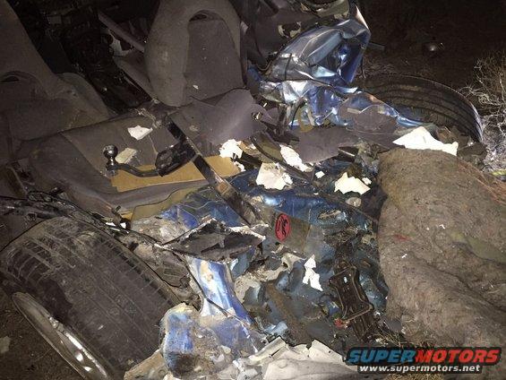 Interior of a heavily damaged blue car with torn seats and crumpled metal