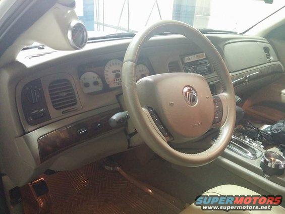 Interior view of a 2000 Mercury Grand Marquis with a gauge pod on the A-pillar and wood trim