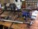 1979 Ford Bronco - Tie rod assembly clamped in a vise on a workbench with various tools and parts.