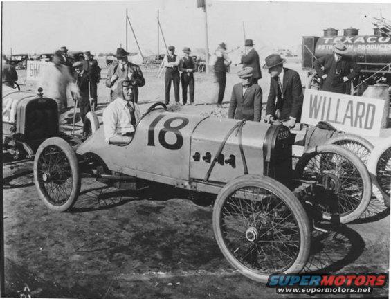 Race car with driver and number 18, with a Willard sign and Texaco tanker in background