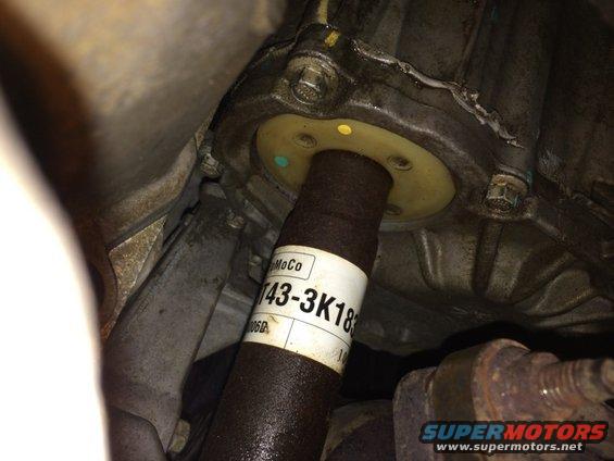 Driveshaft with a white label reading 'MoCo T43-3K183' attached to a vehicle's transmission housing