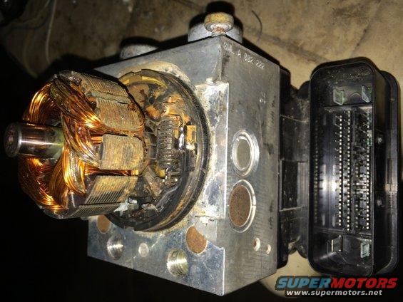 ABS pump motor with copper windings and electrical connector, showing rust and wear