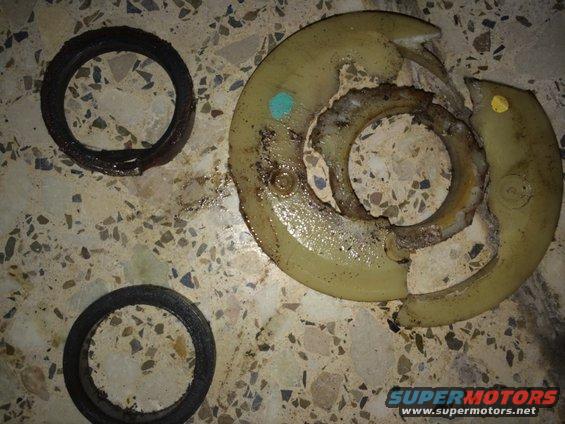 Two rubber seals and a broken plastic component with metal inserts on a terrazzo floor