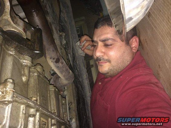 Underbody view of vehicle drivetrain with mechanic wiping sweat