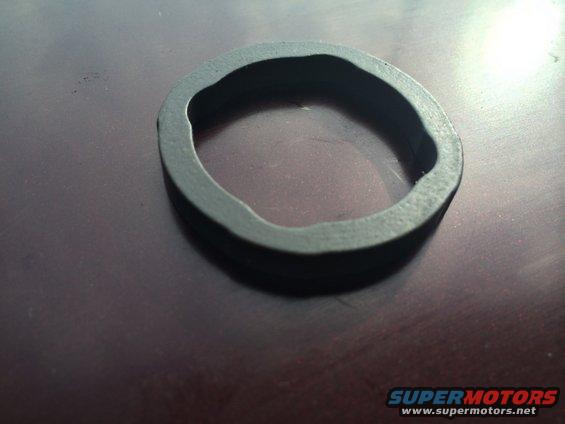 Close-up of a dark, irregularly shaped rubber seal or gasket on a dark surface