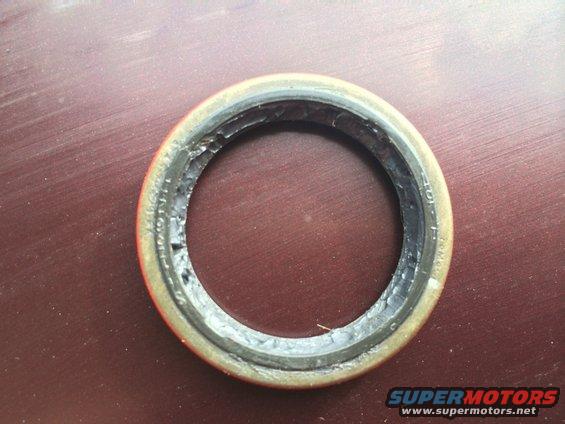 Oil seal with visible damage and text on the inner ring