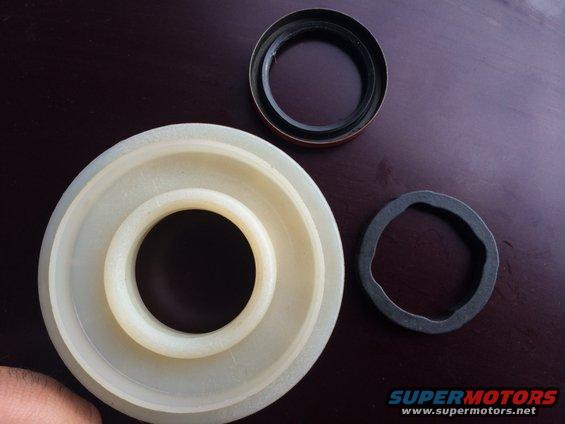 Three automotive seals or rings on a dark surface