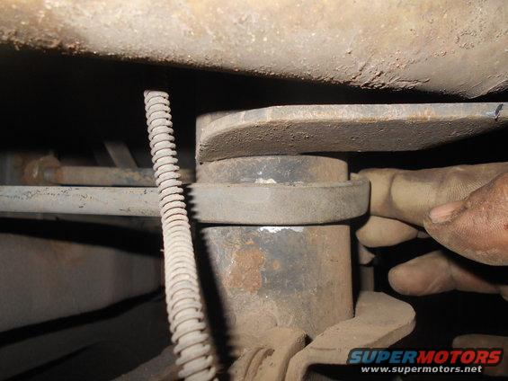 Close-up of a hand adjusting a vehicle's suspension lift block