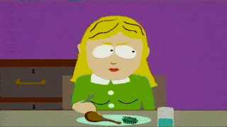 Blonde woman in green shirt eating from a plate with a fork