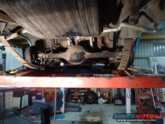 1964 Mercury Monterey rear axle assembly on a lift, showing leaf springs and fuel tank