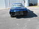 1972 Ford Ranchero - The front of a blue car is shown, with the grille and headlights removed, parked in front of a metal building.