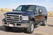 2005 Ford F-250 - A black Ford Super Duty truck is parked outdoors on a sunny day.