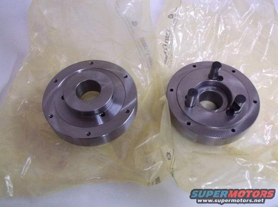 Two metal chucks, one with three pins, wrapped in plastic