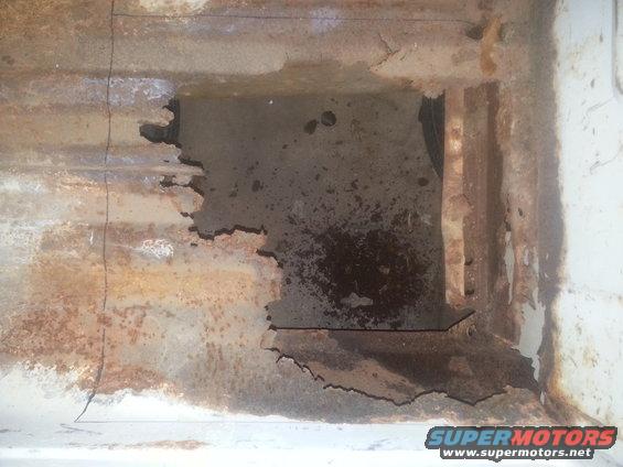 Heavily rusted metal frame with a large hole, showing internal structure