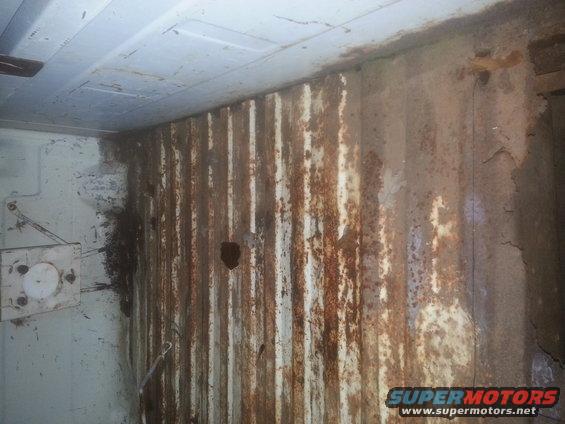 Interior panel with significant rust damage and vertical corrugations