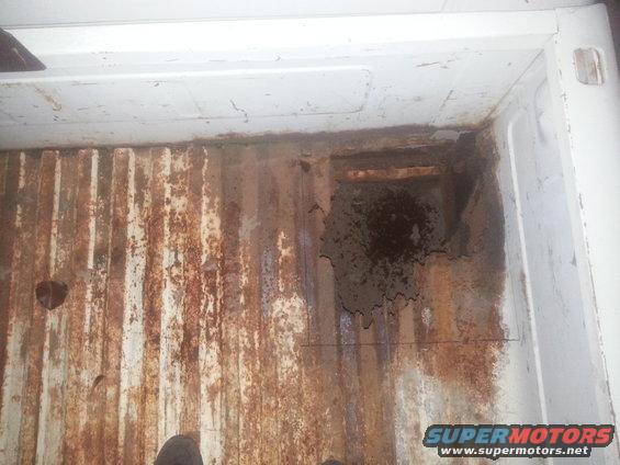 rusted truck bed with visible damage and wear