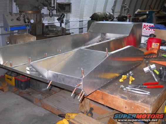 aluminum boat hull being built on workbench with tools