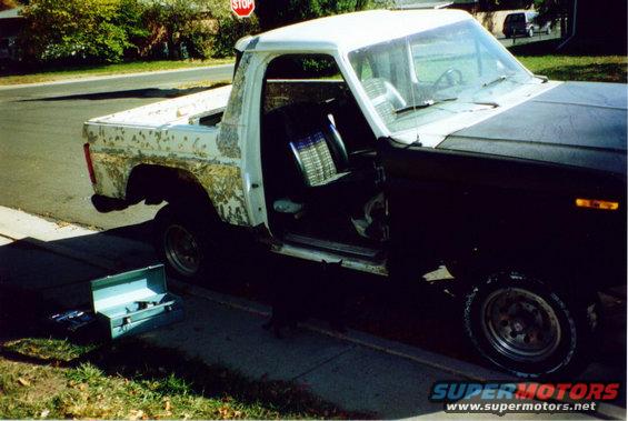 Ford pickup truck with doors open, showing interior and worn paint on the bed