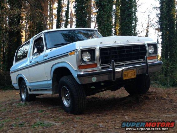 White and blue 1978 Ford Bronco on dirt road, front 3/4 view