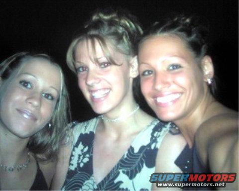Three women smiling for a photo. One has a floral top