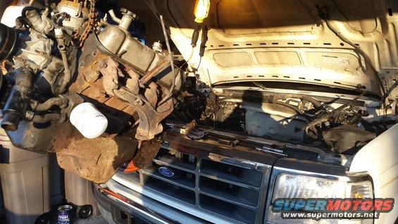 engine hoist lifting out a V8 engine from a Ford truck with hood open