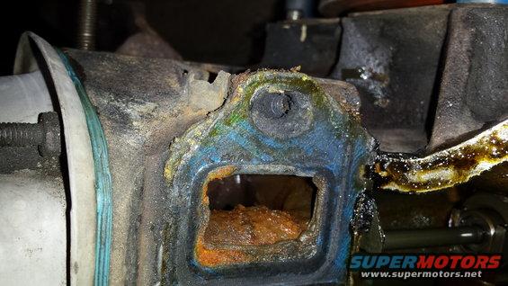Corroded engine part with visible rust and oil residue