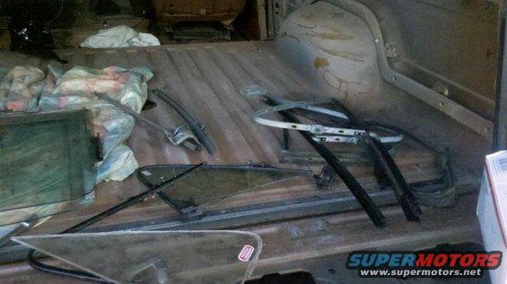 Inside of a vehicle with window parts and fabric bundles on the floor